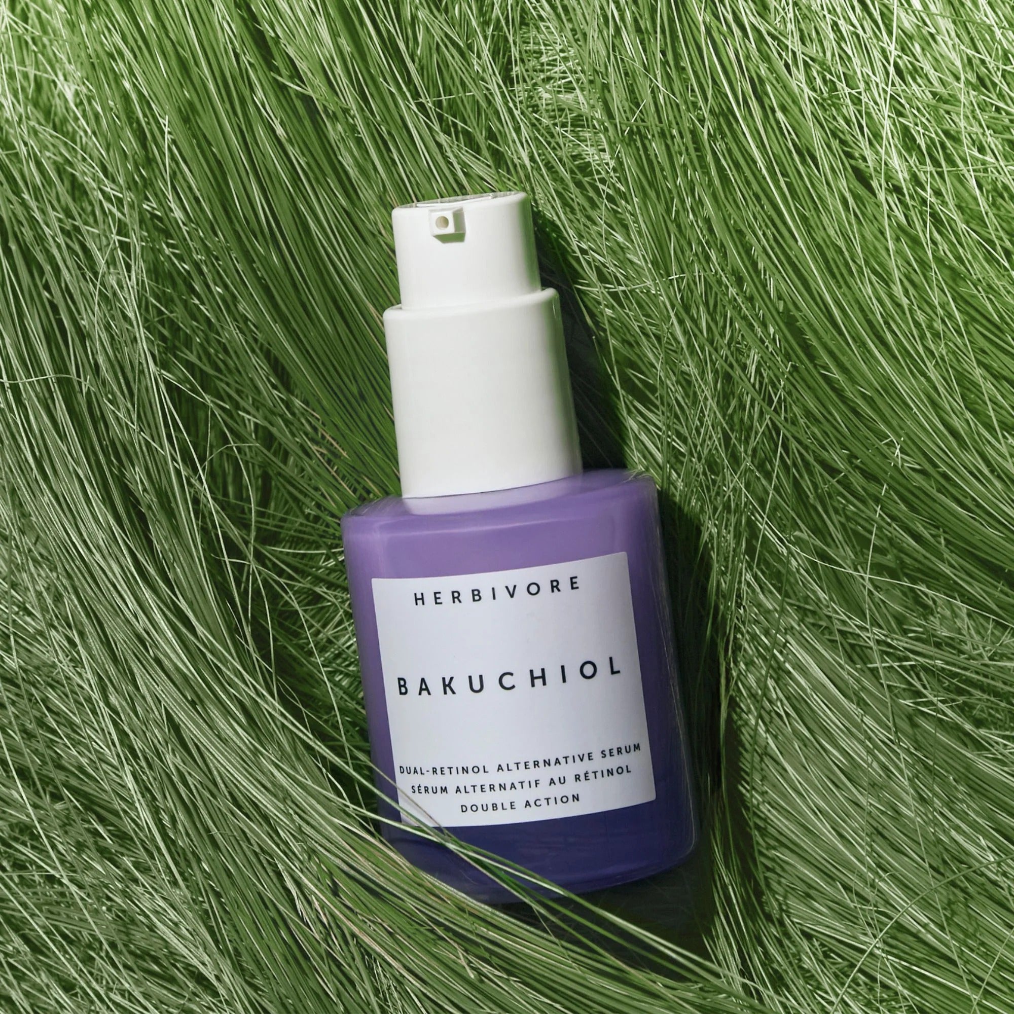 Herbivore Bakuchiol serum bottle on green grass