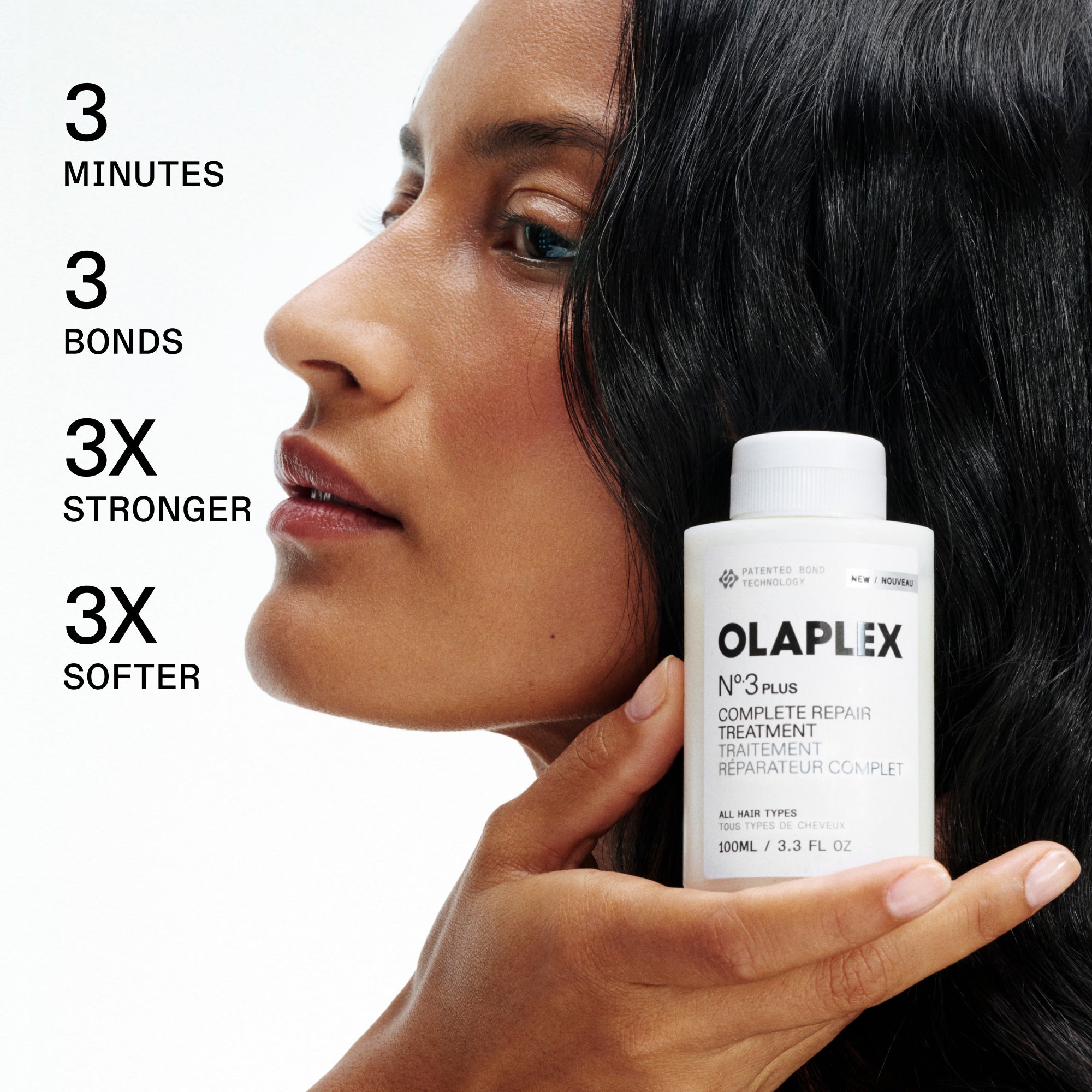 Woman holding Olaplex hair treatment with product details on a white background
