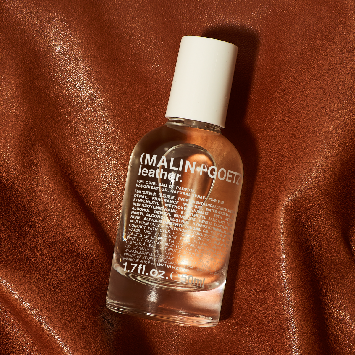 Bottle of Malin+Goetz leather fragrance on a brown leather background