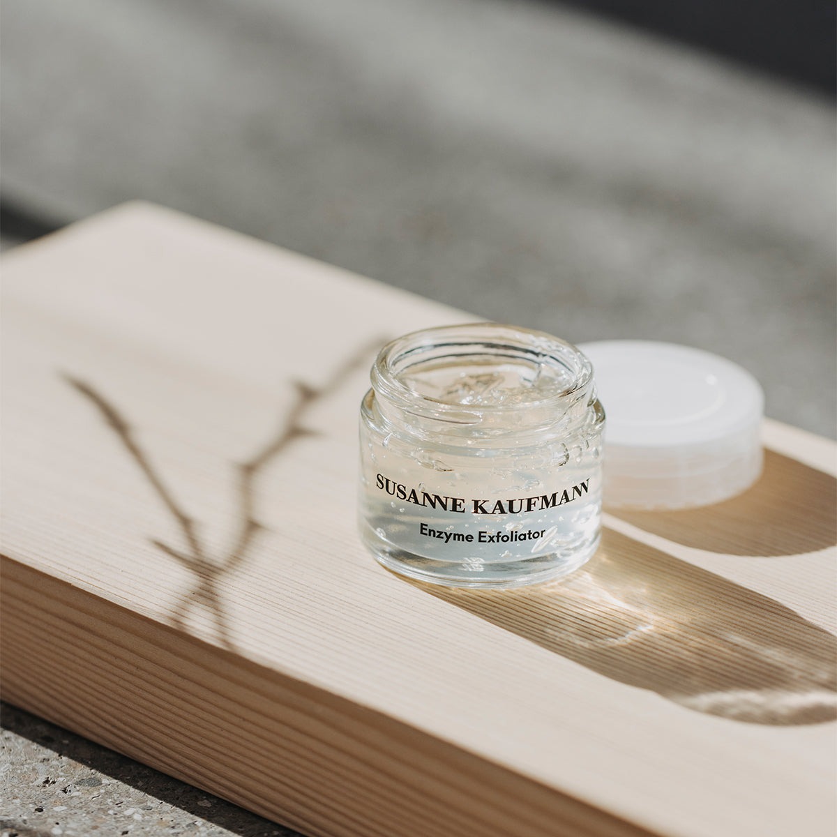 Susanne Kaufmann Enzyme Exfoliator jar on a wooden surface with natural light