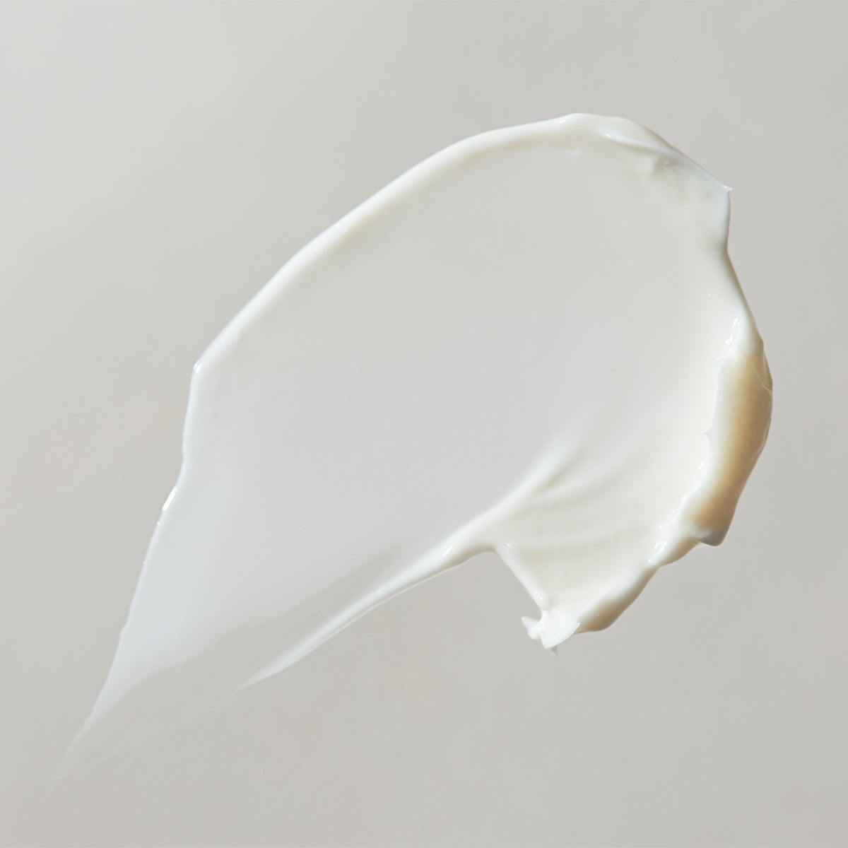 Close-up of a white cream swatch on a light gray background