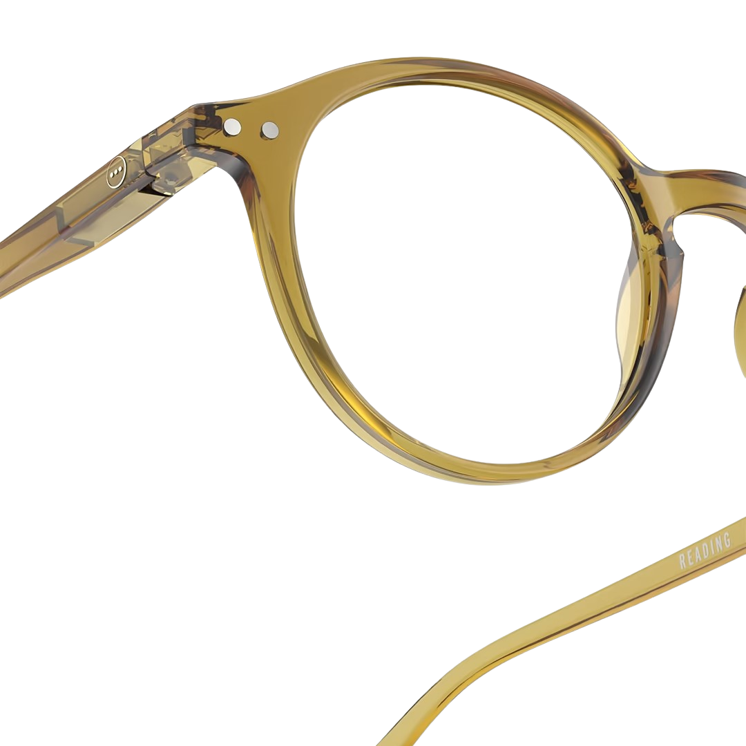Close-up of a pair of eyeglasses with a golden green frame on a white background