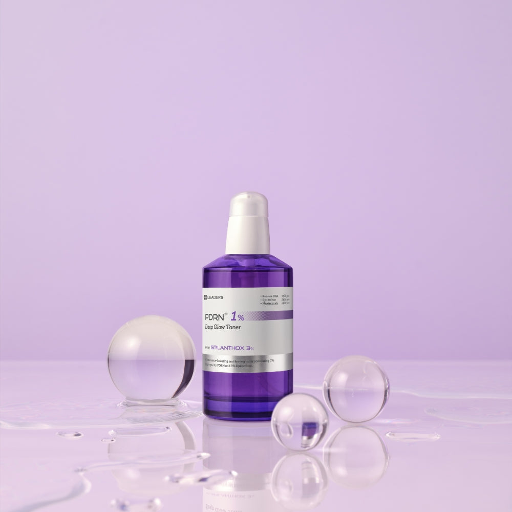A purple glass bottle of ROX1% Dry Skin Power serum with a white pump dispenser, set on a reflective surface with clear glass spheres against a light purple background.