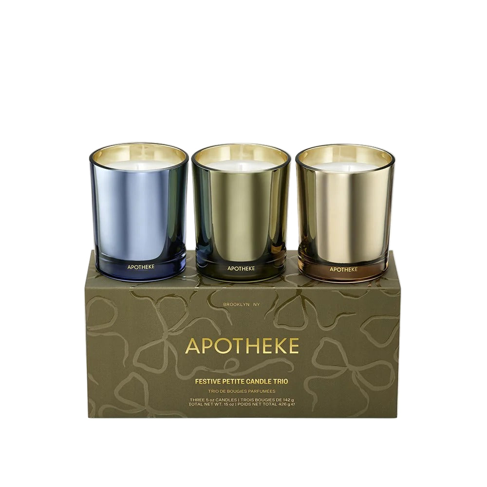 Three small candles in metallic holders on a decorative box with 'Apotheke' branding.