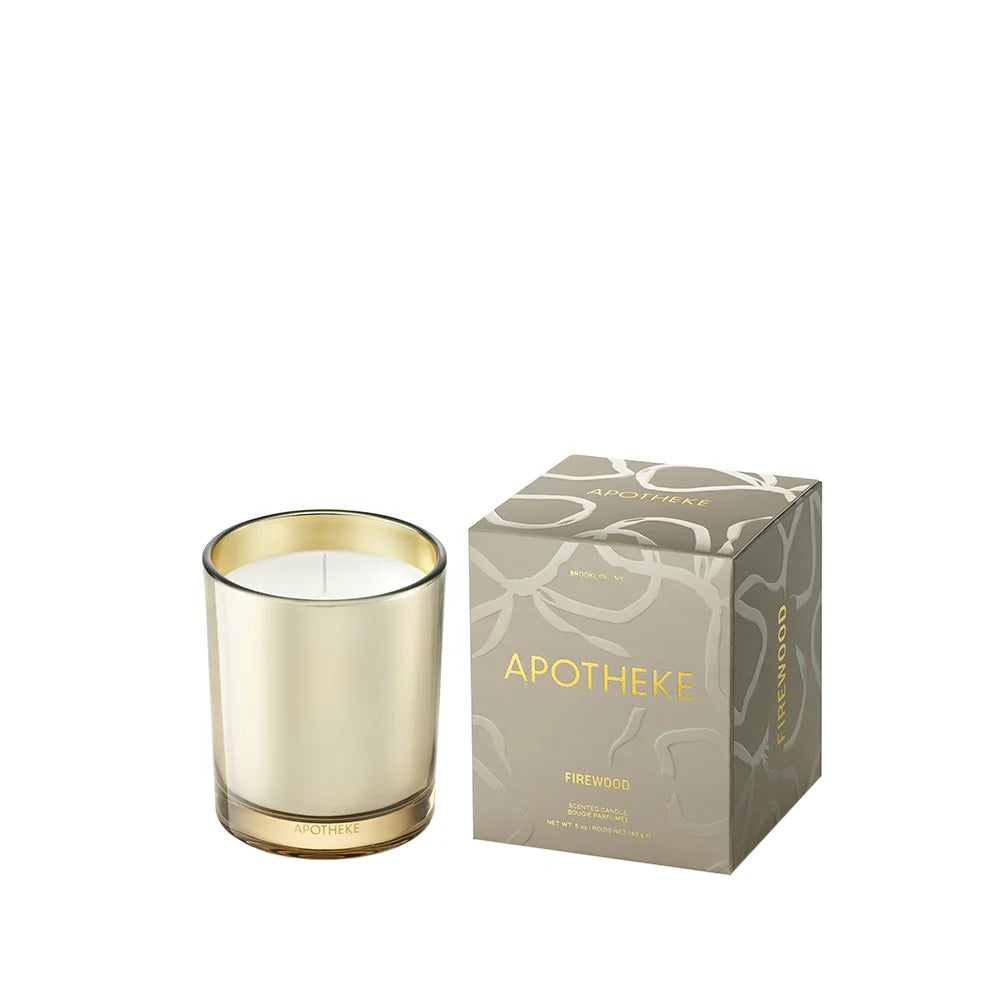 Candle with gold rim and matching packaging on a white background