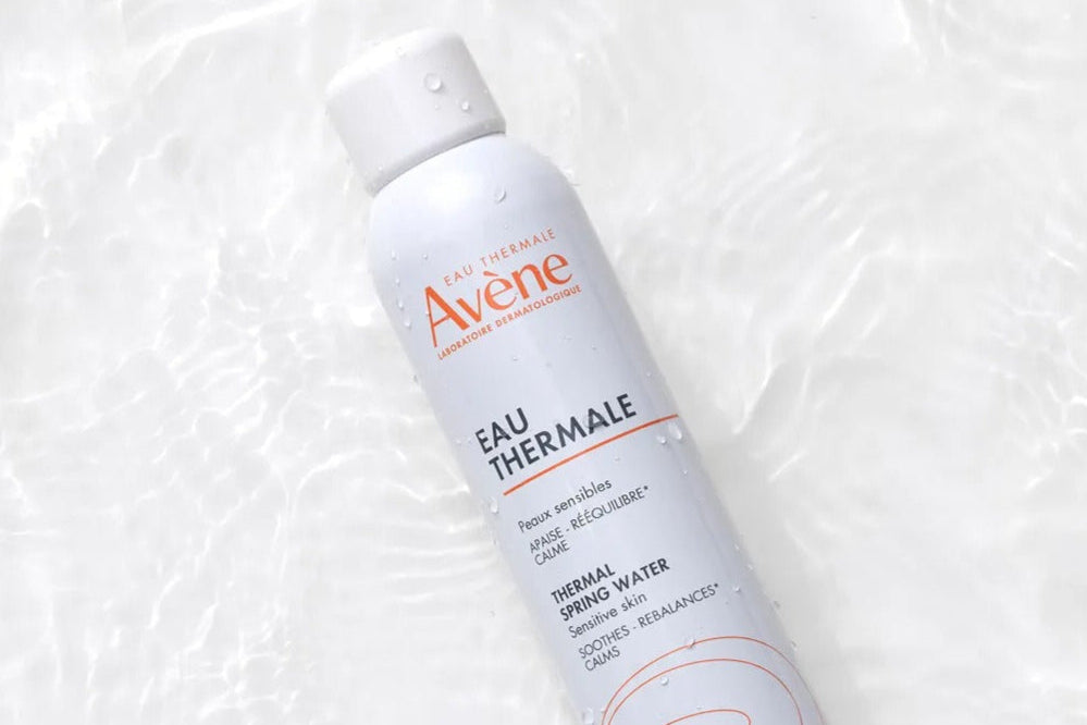 Avene bottle on a textured white background