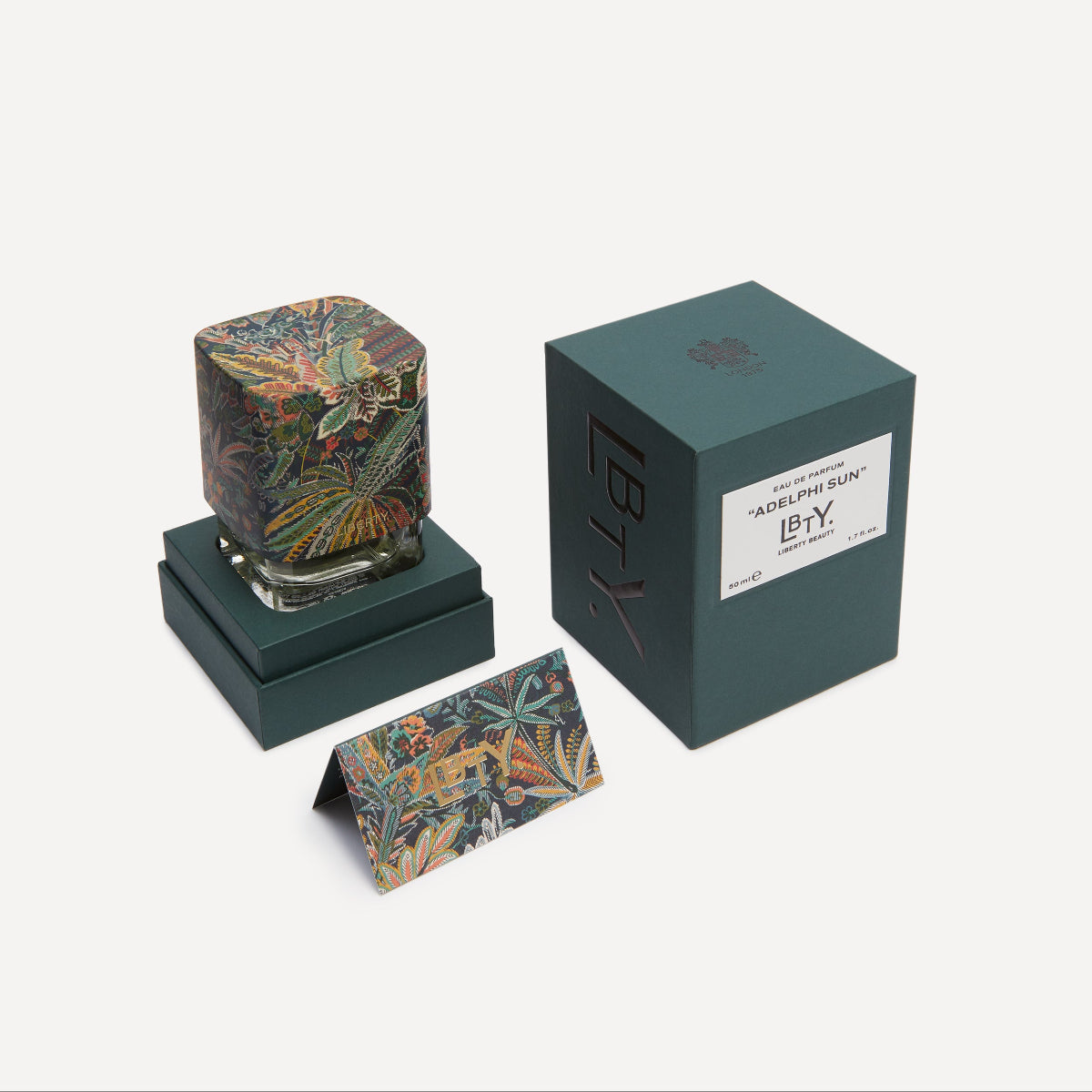Adephi Sun EDP bottle with floral design, green box, and business card on a white background