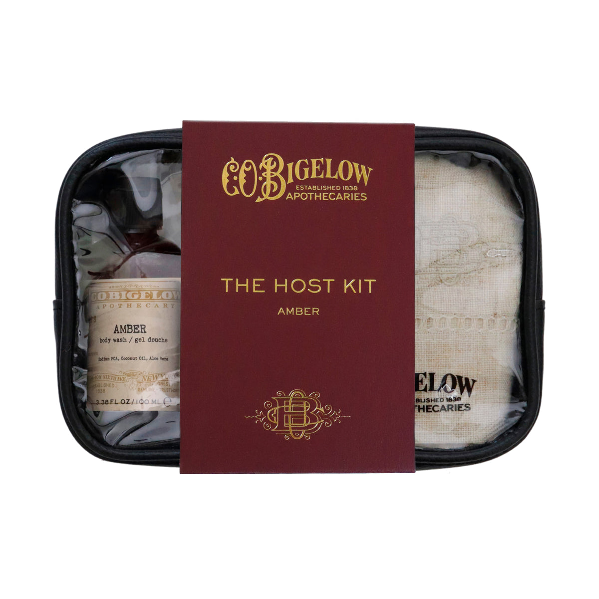 CoBigelow Apothecaries 'The Host Kit' amber set, featuring a burgundy and gold central card, a small amber bottle, and a beige cloth inside a black zippered case on a white background.