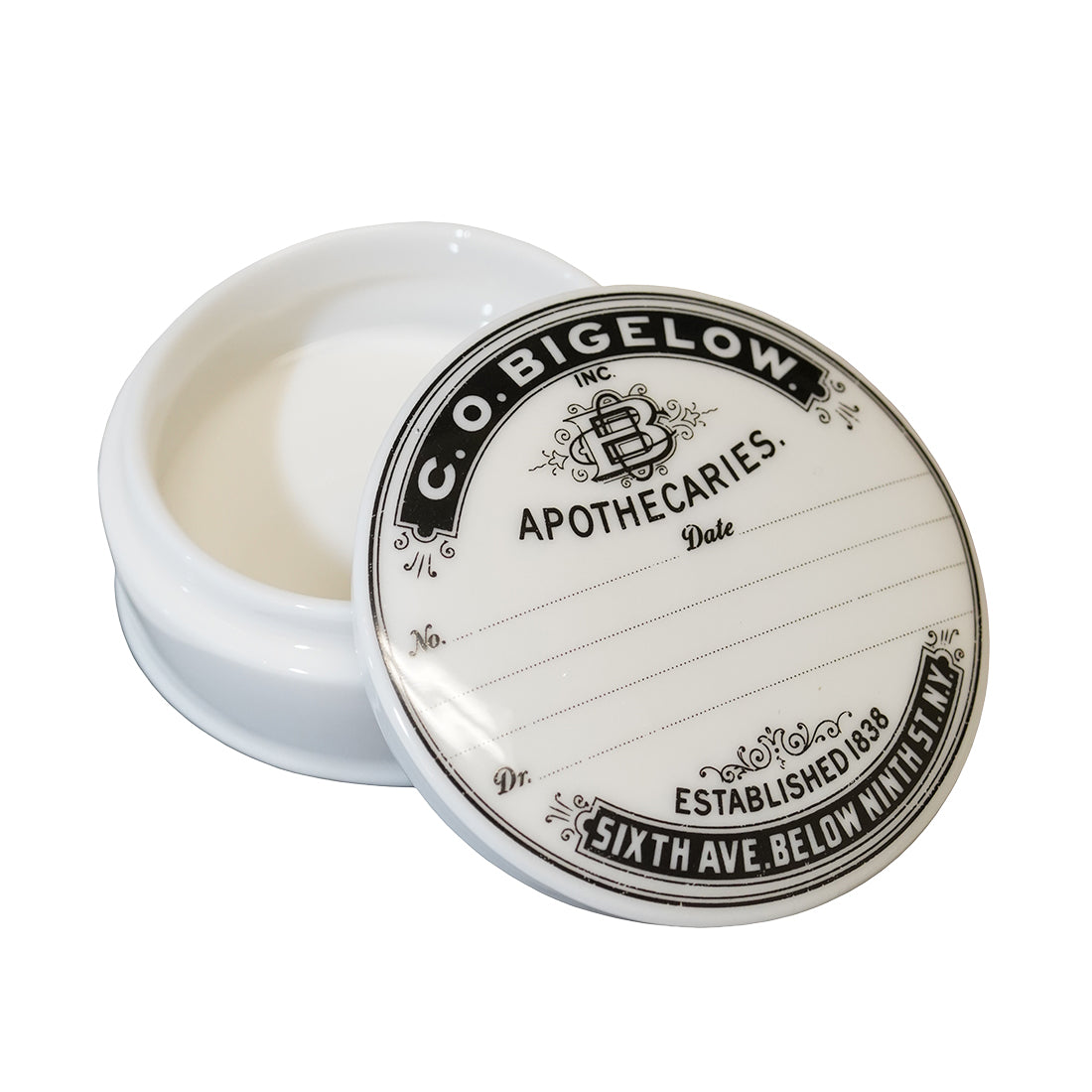 An open round white jar with a decorative white lid featuring black printed text that reads 'C. O. Bigelow'