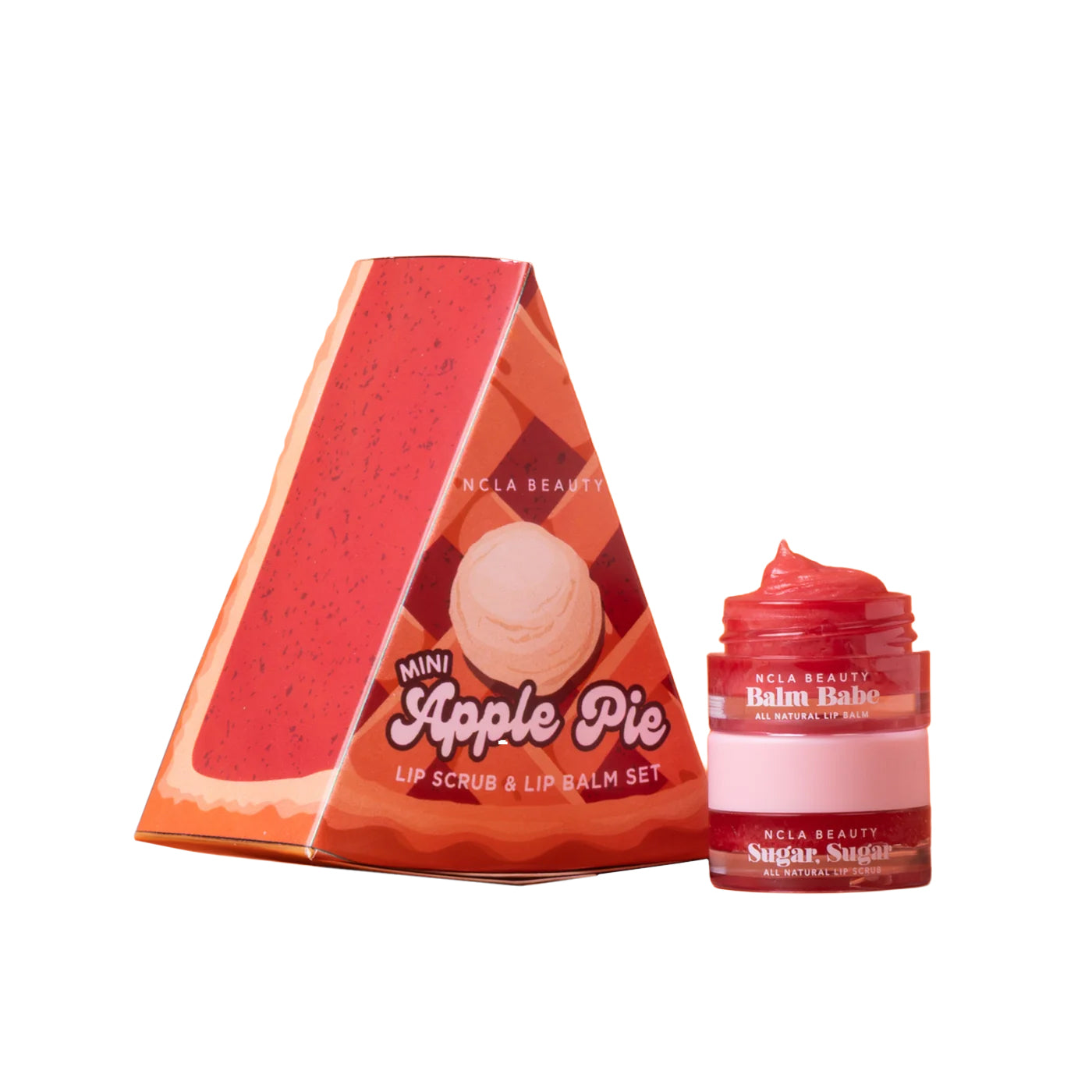 NCLA Beauty Mini Apple Pie lip scrub and lip balm set, featuring a triangular red and orange box with an apple pie illustration next to an open jar of red balm and a pink lip scrub.