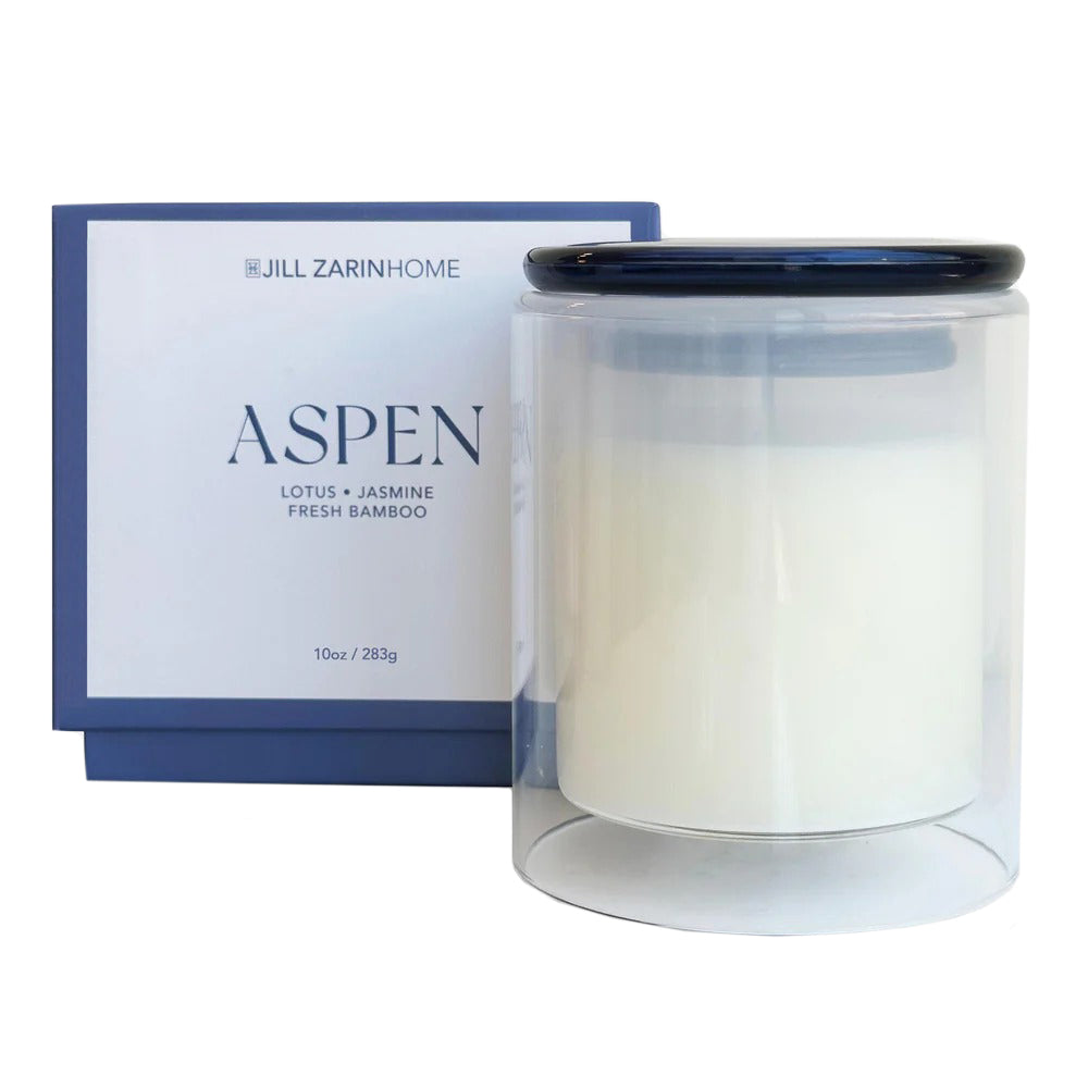 Jill Zarin Home Aspen candle in a clear container with a blue box on a white background