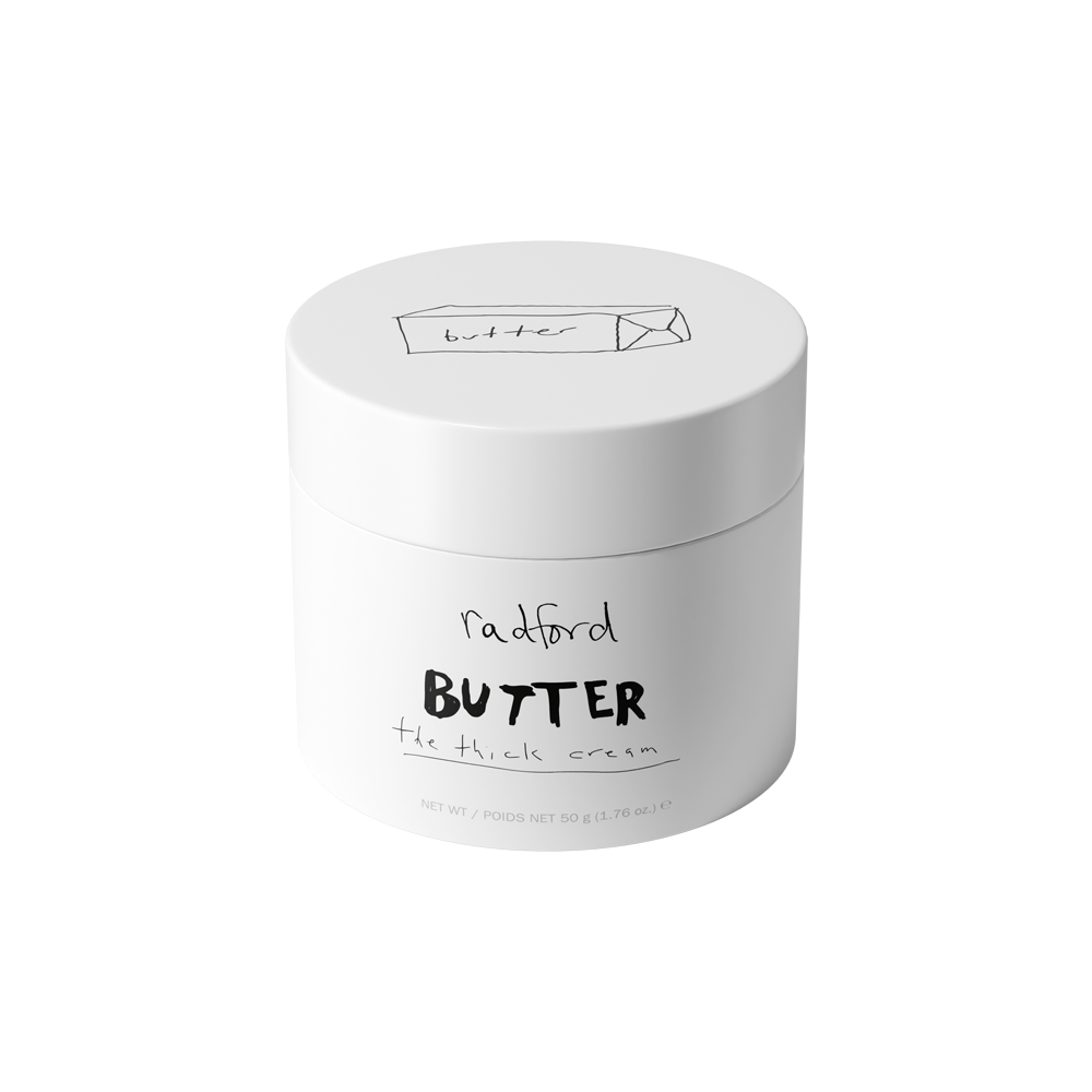 A white plastic jar of Radford Butter -  The Thick Cream with black printed text and a simple line drawing of a butter box on the lid, set against a plain white background.