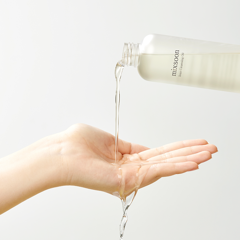 mixsoon Bean Cleansing Oil pouring into the palm of a hand, against a clean white background.