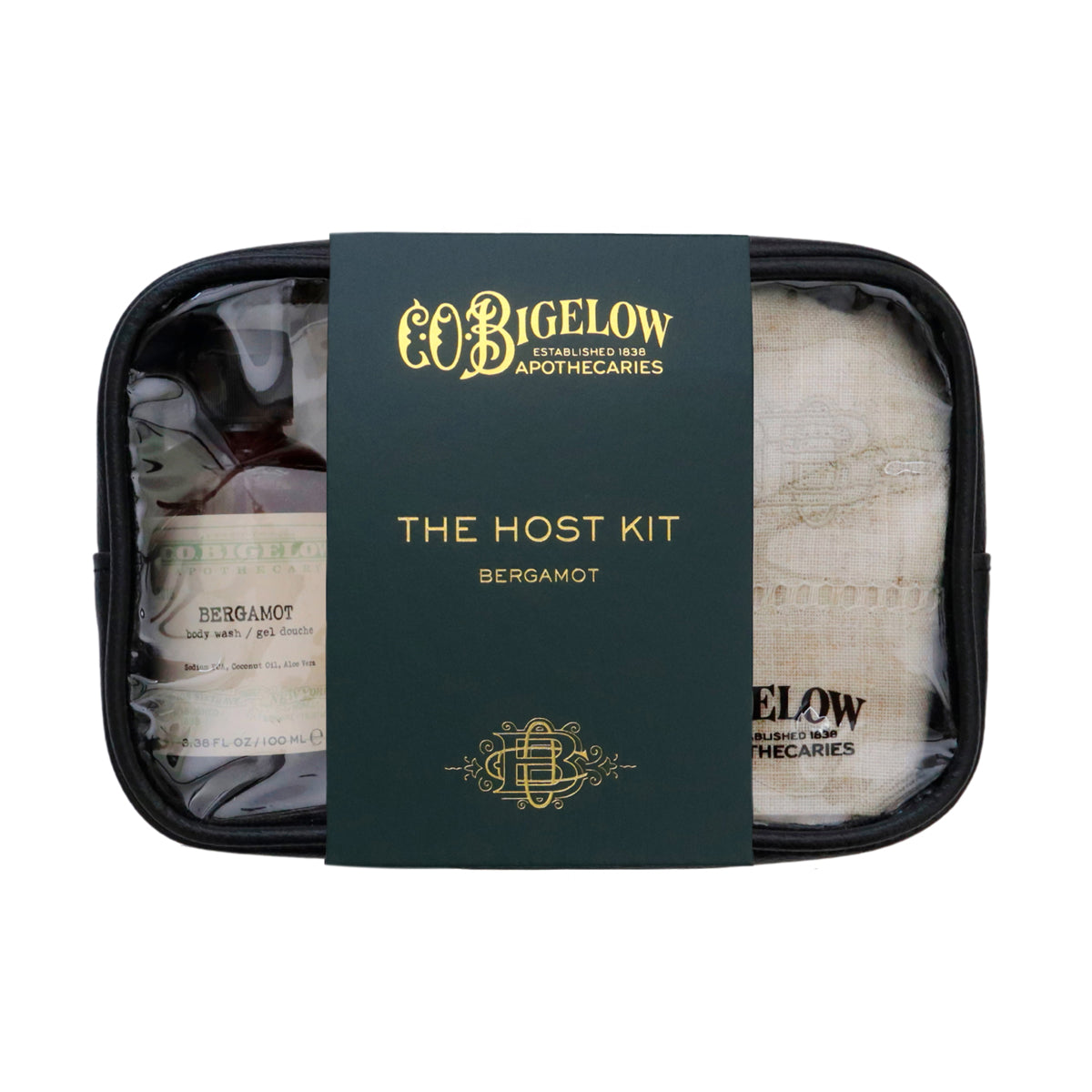 Bigelow Apothecaries 'The Host Kit' containing a Bergamot bottle, a linen towel, and a soap bar, all neatly arranged inside a black zippered case with a dark green and gold paper sleeve.