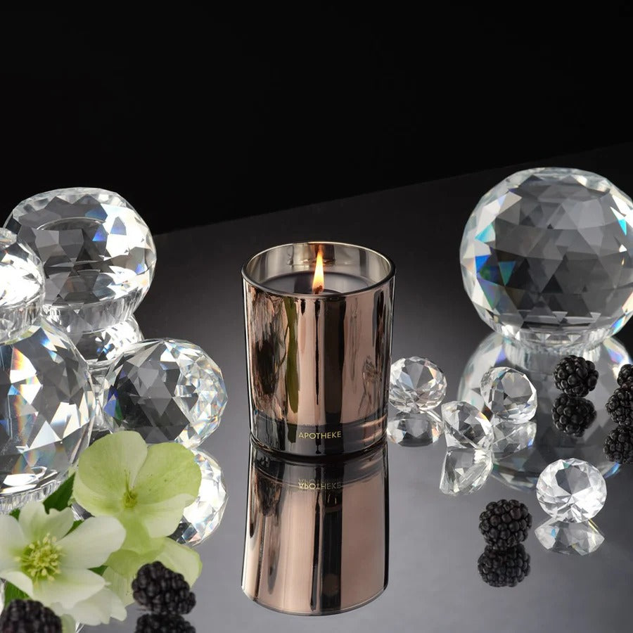 Silver candle with decorative elements on a reflective surface