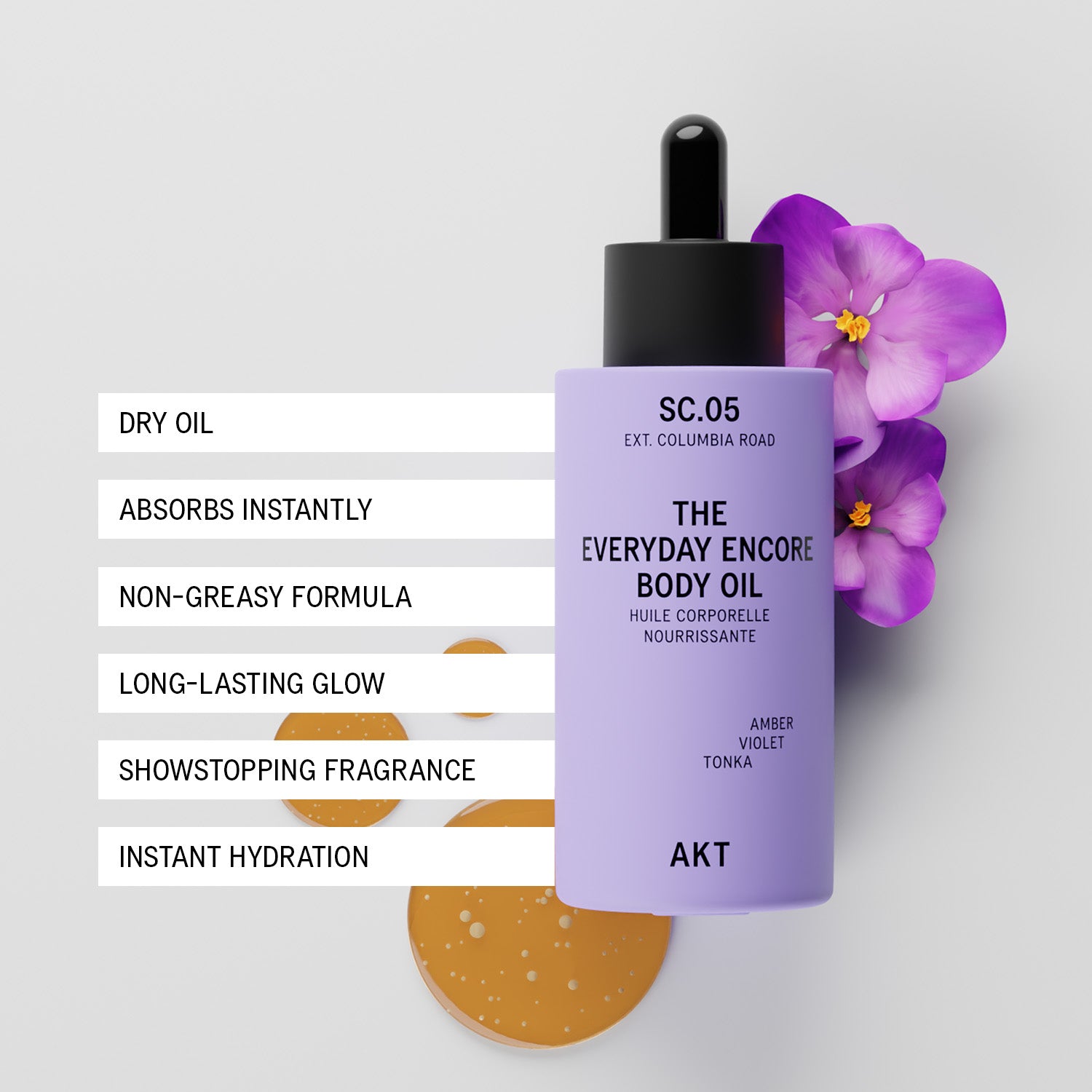 A bottle of AKT SC.05 Everyday Encore Body Oil in amber violet, styled with purple orchids and a dropper cap on a light gray background, accompanied by product feature text overlays and a small gold oil droplet.