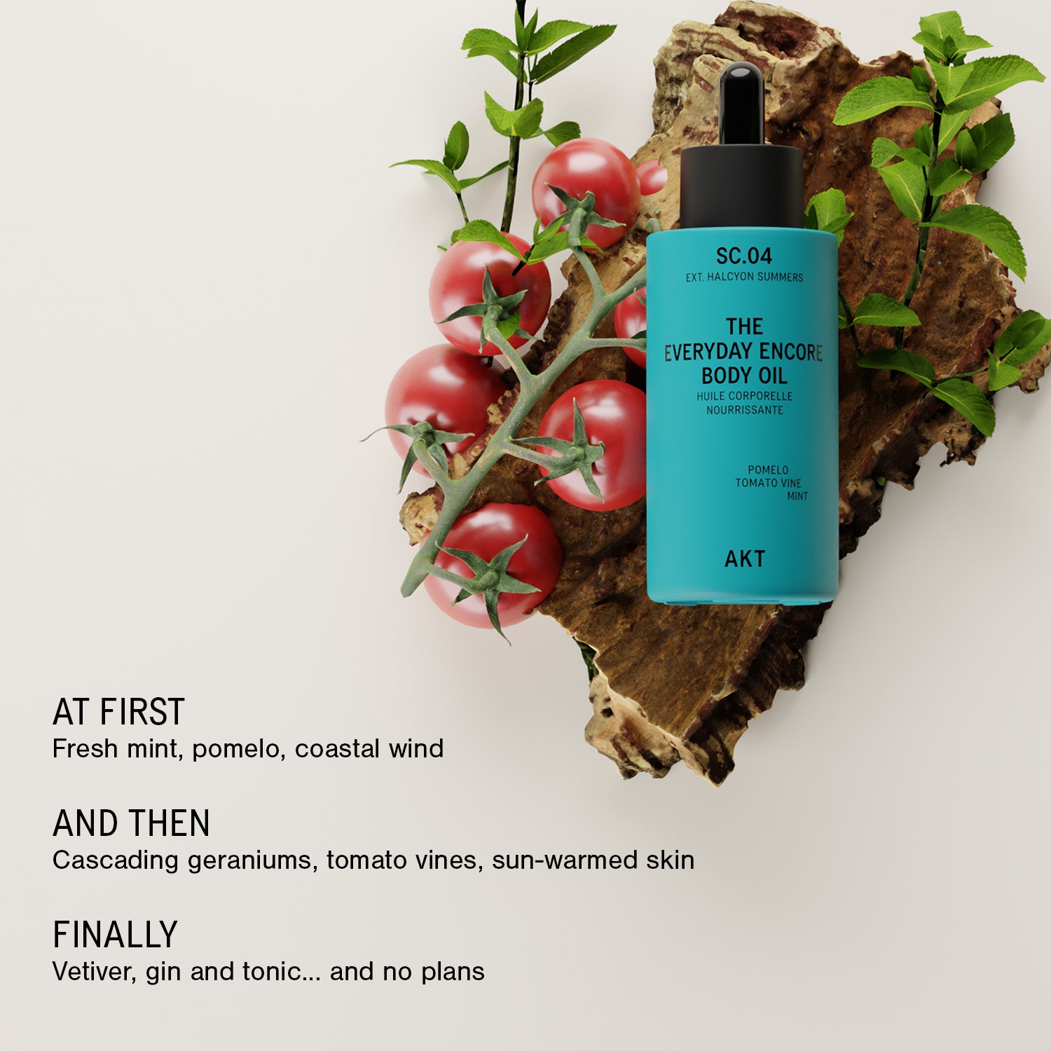 A turquoise dropper bottle labeled 'THE EVERYDAY ENCORE BODY OIL' with a black dropper cap, styled on a wood slab with green leaves and red tomatoes against a light gray background. Text on the left reads: 'AT FIRST Fresh mint, pomelo, coastal wind' and 'AND THEN Cascading geraniums, tomato vines, sun-warmed skin' and 'FINALLY Vetiver, gin and tonic.