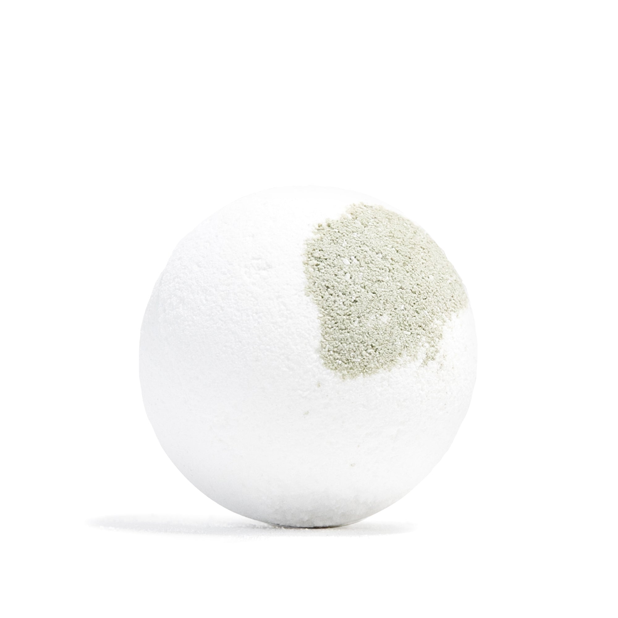 A white bath bomb with a textured light green powder coating on one side, shown on a clean white background.