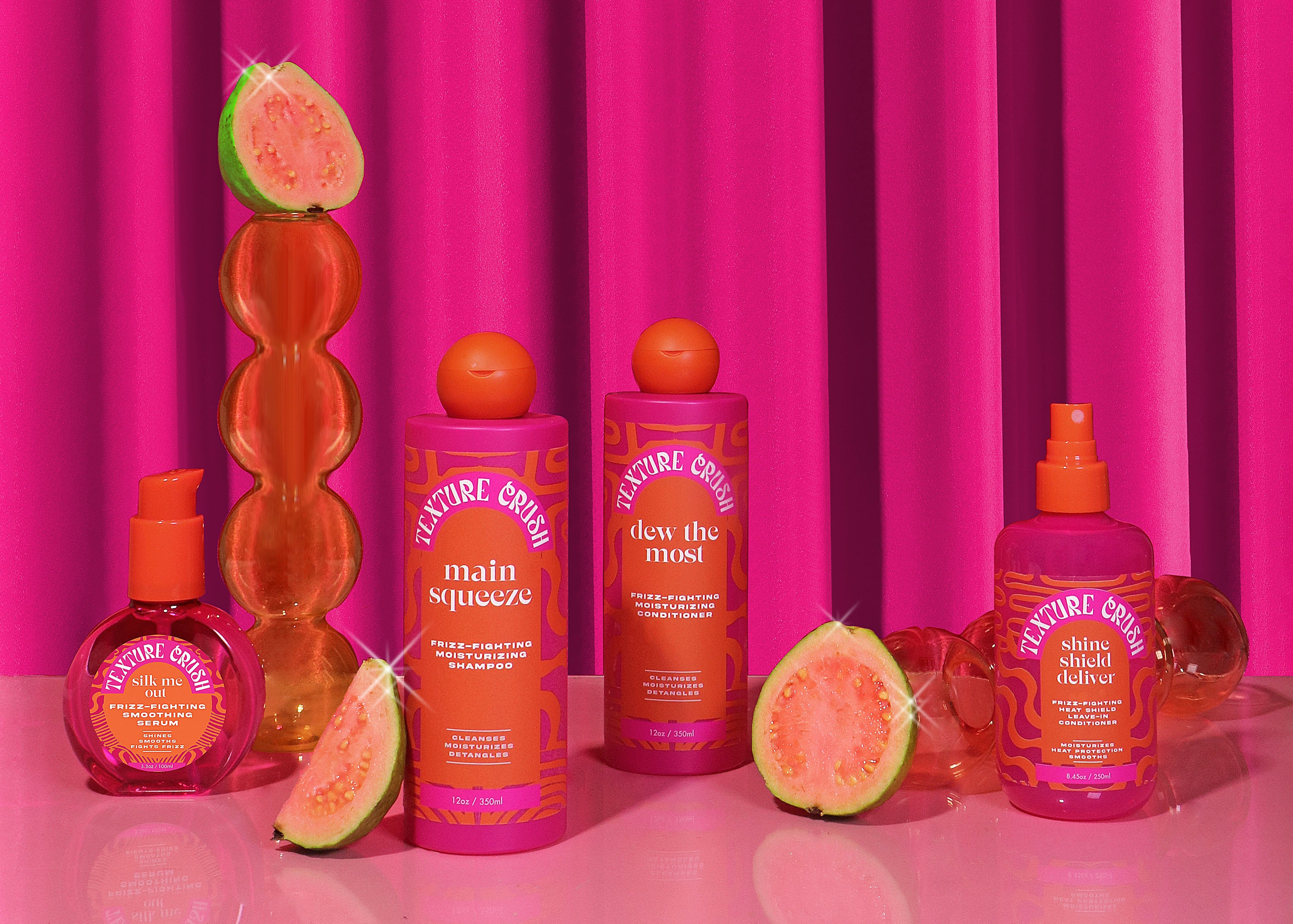 Cosmetic products with guava slices against a pink curtain background