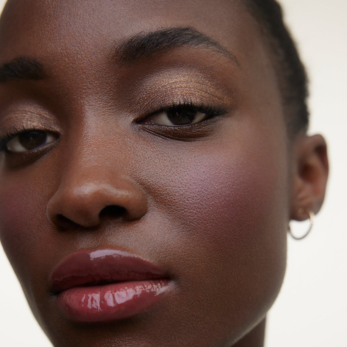Closeup of woman's face wearing Wonderblush makeup products. 