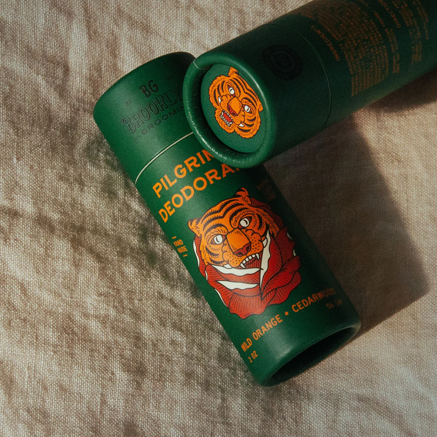 Green deodorant can with tiger design on a textured surface