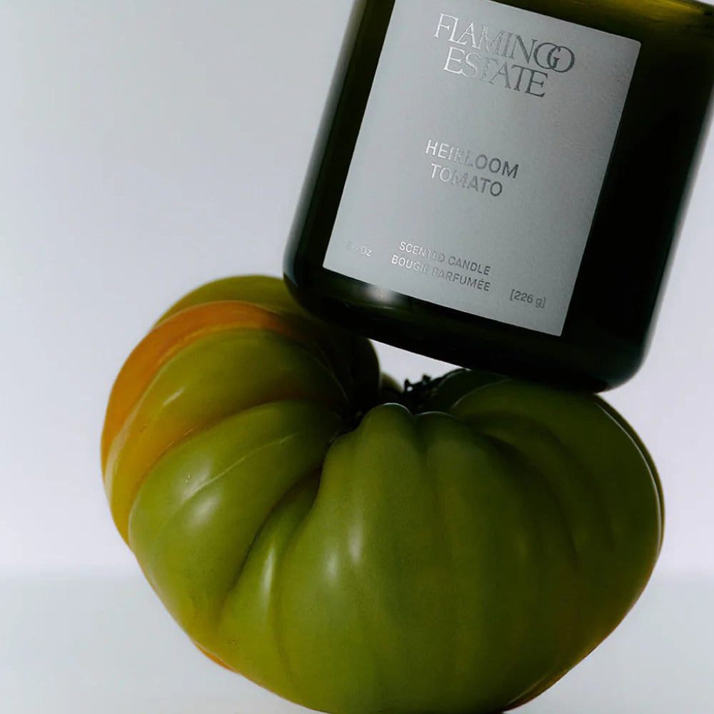 Flamingo Estate Heirloom Tomato candle next to a green tomato 