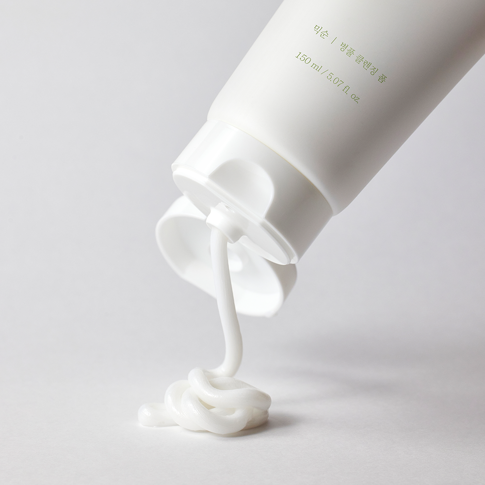 A tube of Mixsoon Centella Cleansing Foam being squeezed out on a white surface