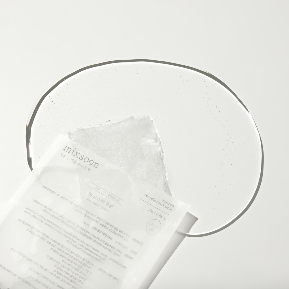 A close-up Centella Mask Pack sheet partially pulled from its white and clear packaging, with a large clear oval shape behind it on a white background.