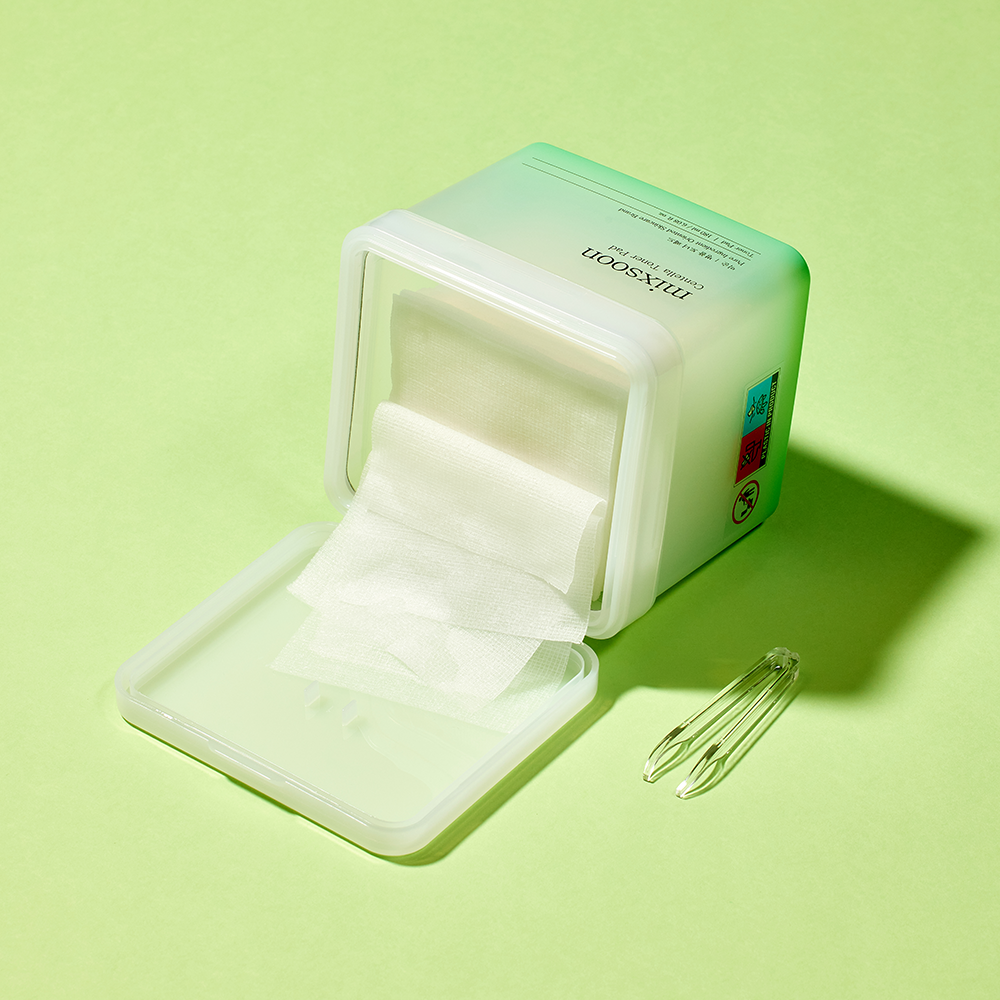 Mixsoon Centella Toner Pad container shown on a light green background with a small clear tongs beside it. 