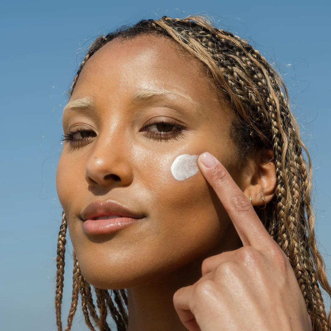 Person applying COOLA Classic Face Sunscreen product to their face