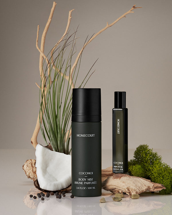  'Homecourt Cocomoi body mist and perfume oil on a neutral background with natural elements.