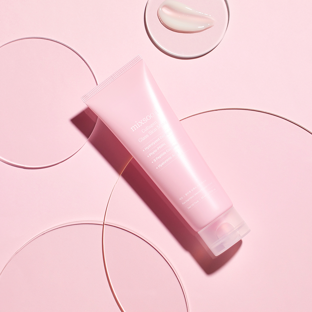 A pink tube of mixsoon Collagen Glass Skin Mask with a translucent cap, styled diagonally on a pink background with minimalist circular line art and a small cream dollop in a top circular dish.