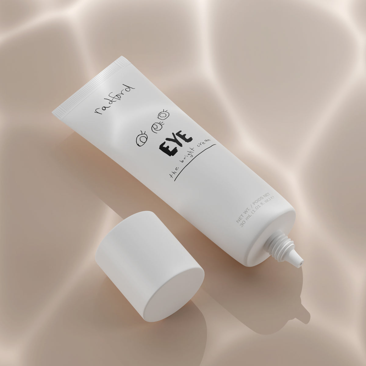 A white squeeze tube of Radford Eye -the Bright Cream with its cap off, placed diagonally on a soft beige satin background with elegant draped shadows.