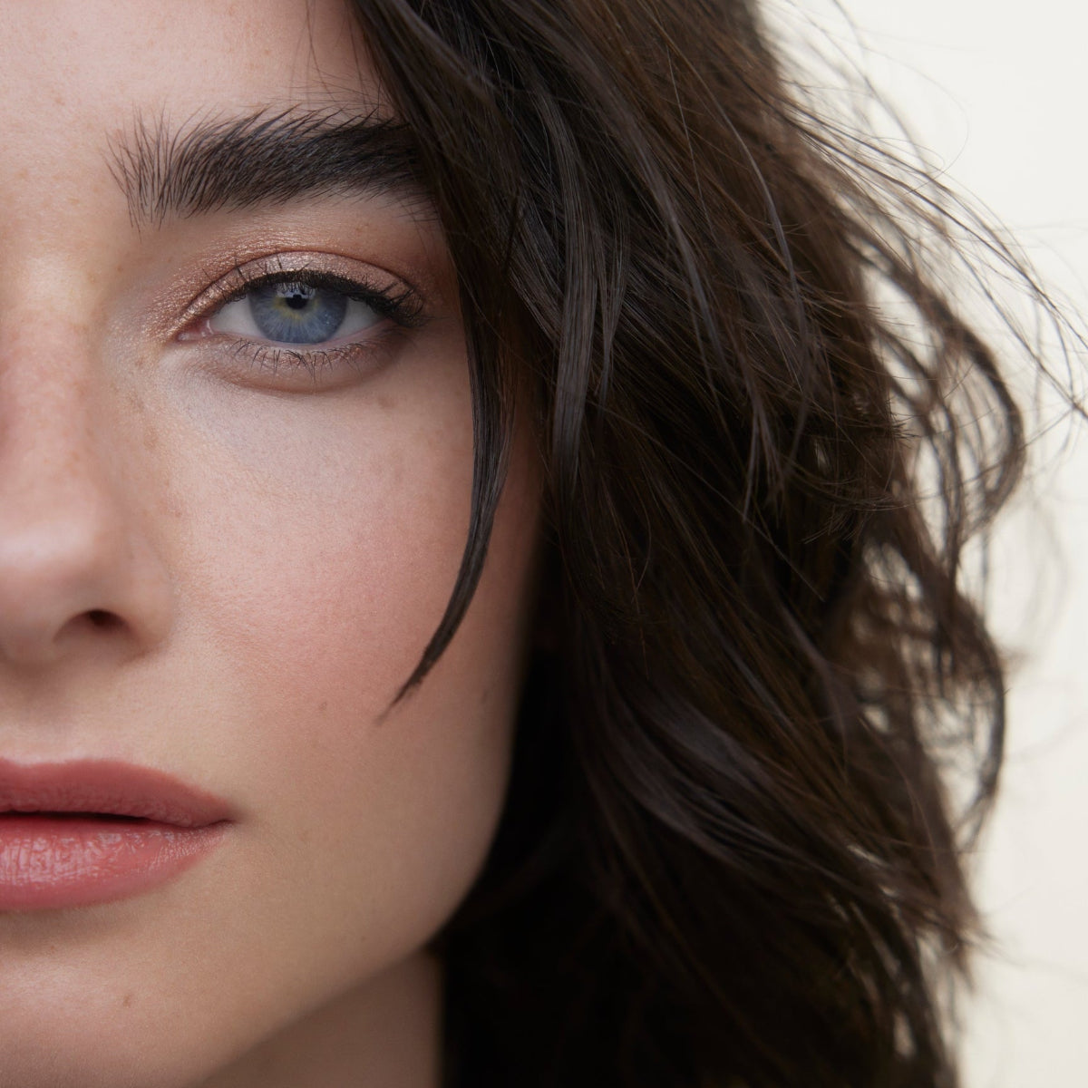 Closeup of woman's face wearing Wonderblush makeup products. 