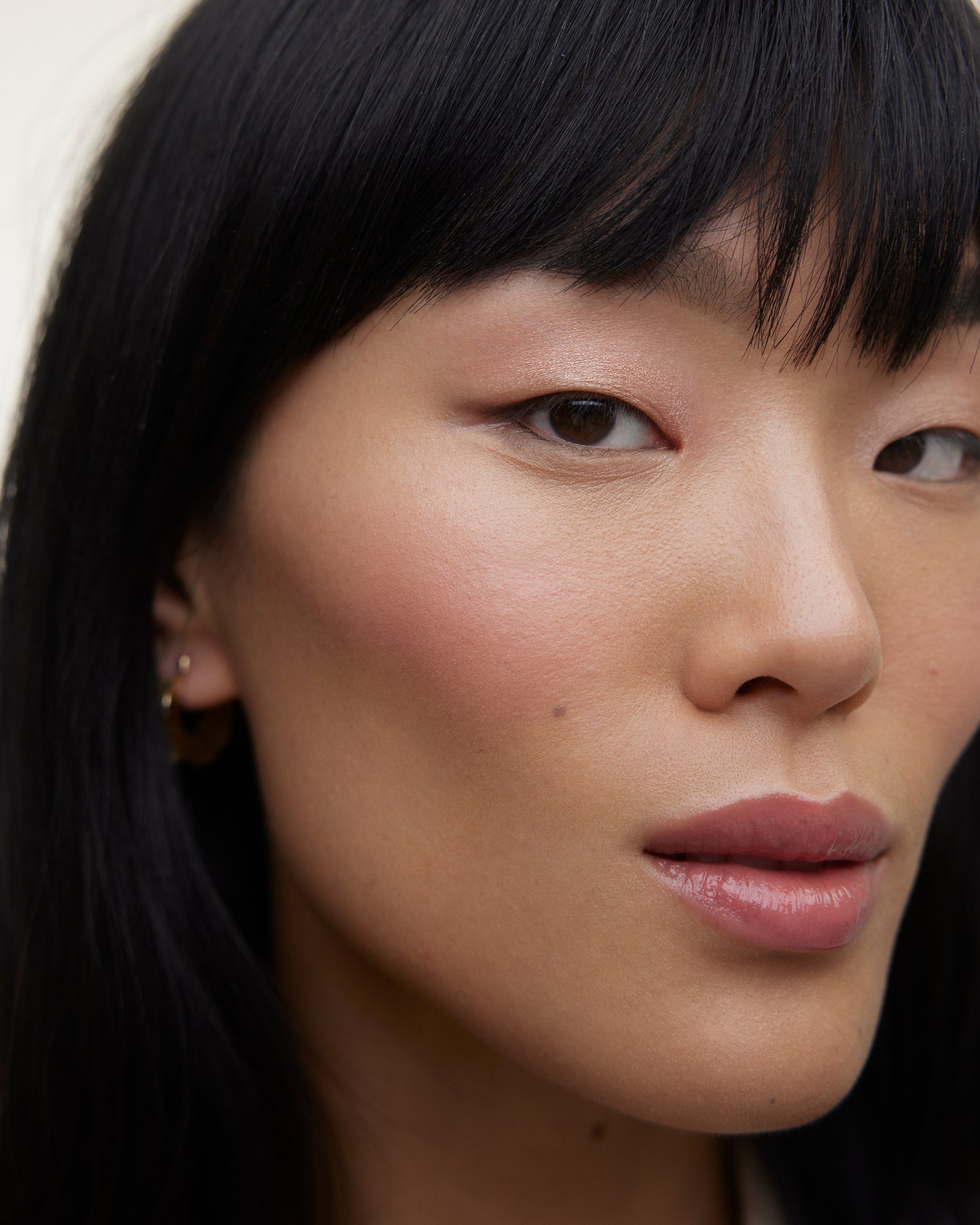 Closeup of woman's face wearing Wonderblush makeup products. 