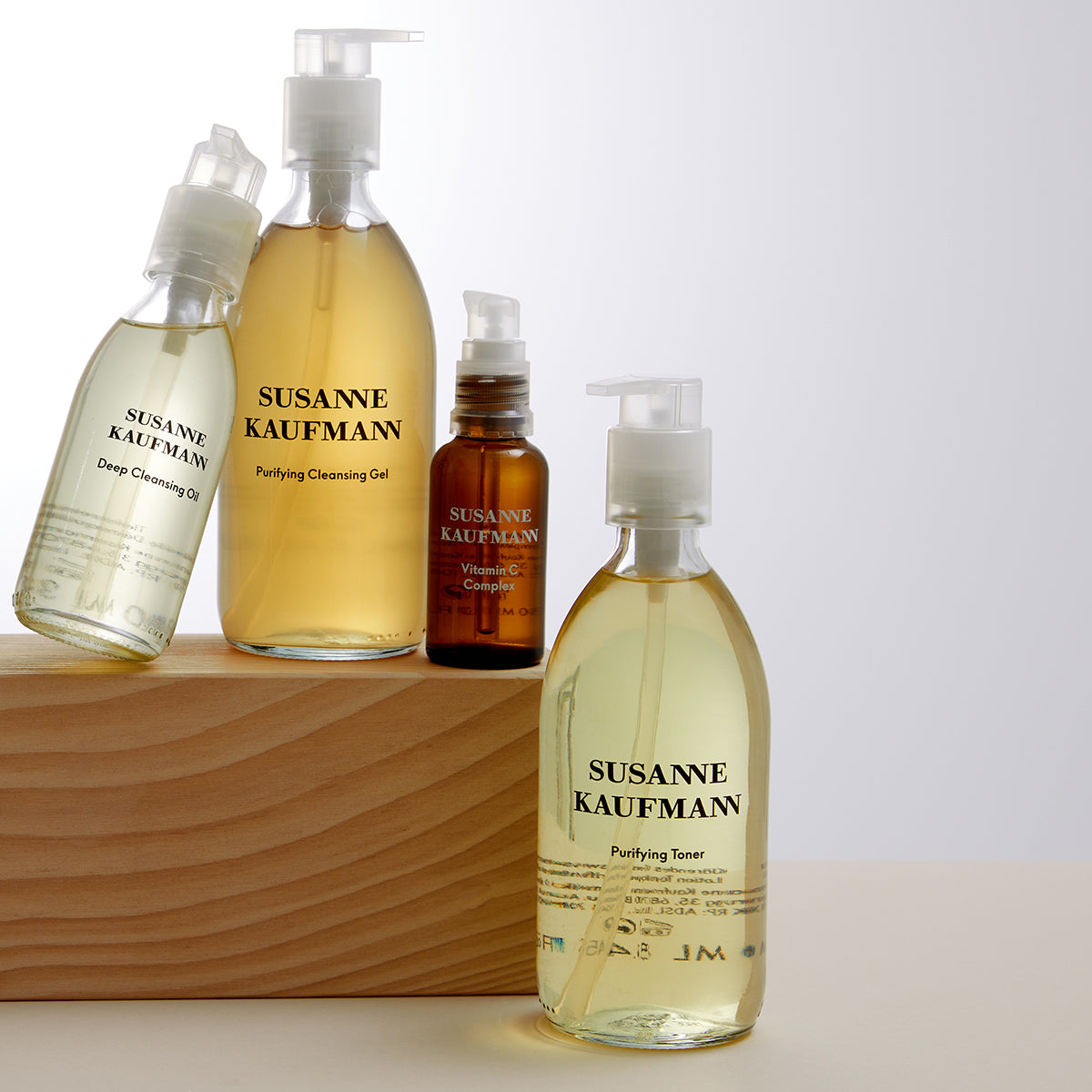Collection of Susanne Kaufmann skincare products on a wooden block with a light background