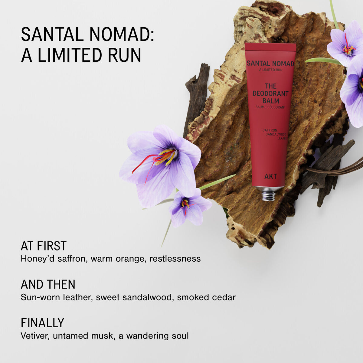 A red tube of Santal Nomad The Deodorant Balm by AKT is displayed on a rustic piece of wood with purple flowers, set against a light gray background with descriptive text.