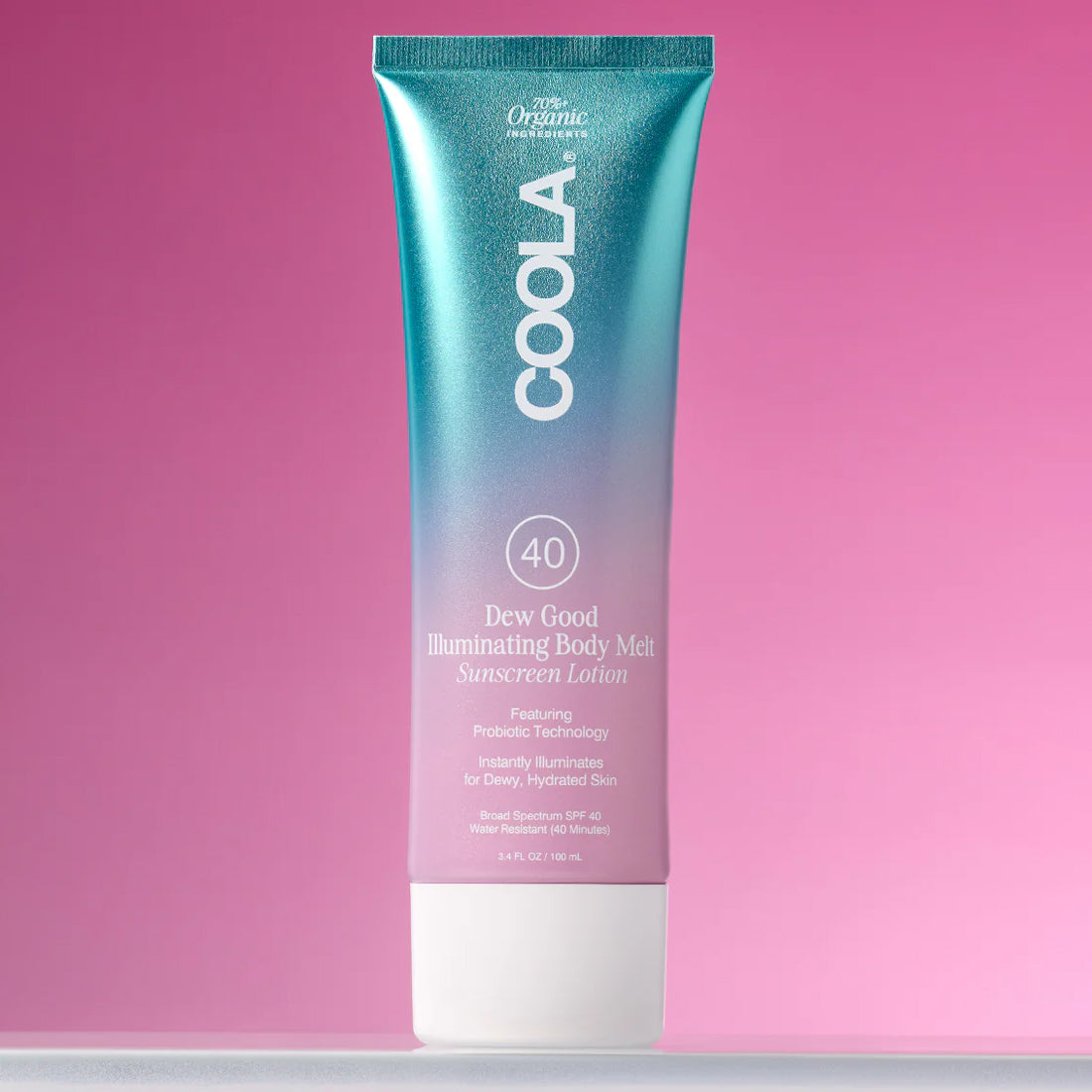 COOLA Dew Good Illuminating Body Melt product on a pink background