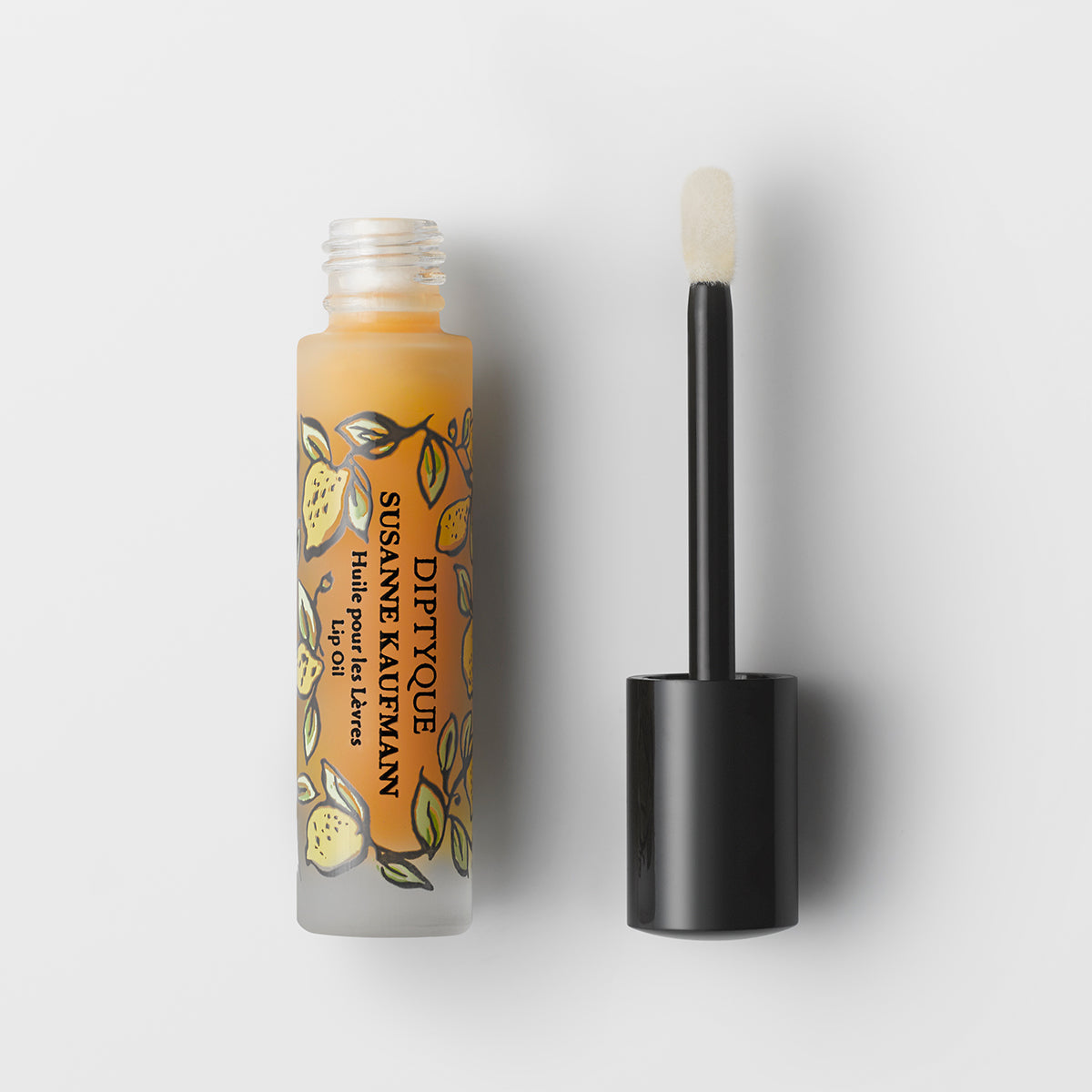 Diptyque lip oil with applicator on a white background