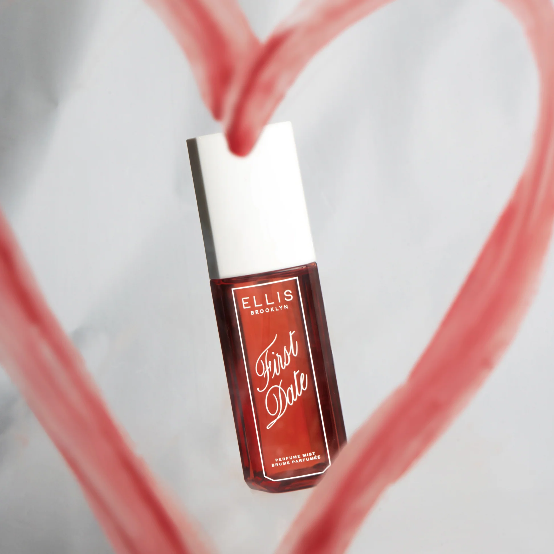 Ellis Brooklyn First Date perfume bottle with pink heart design on a light gray background