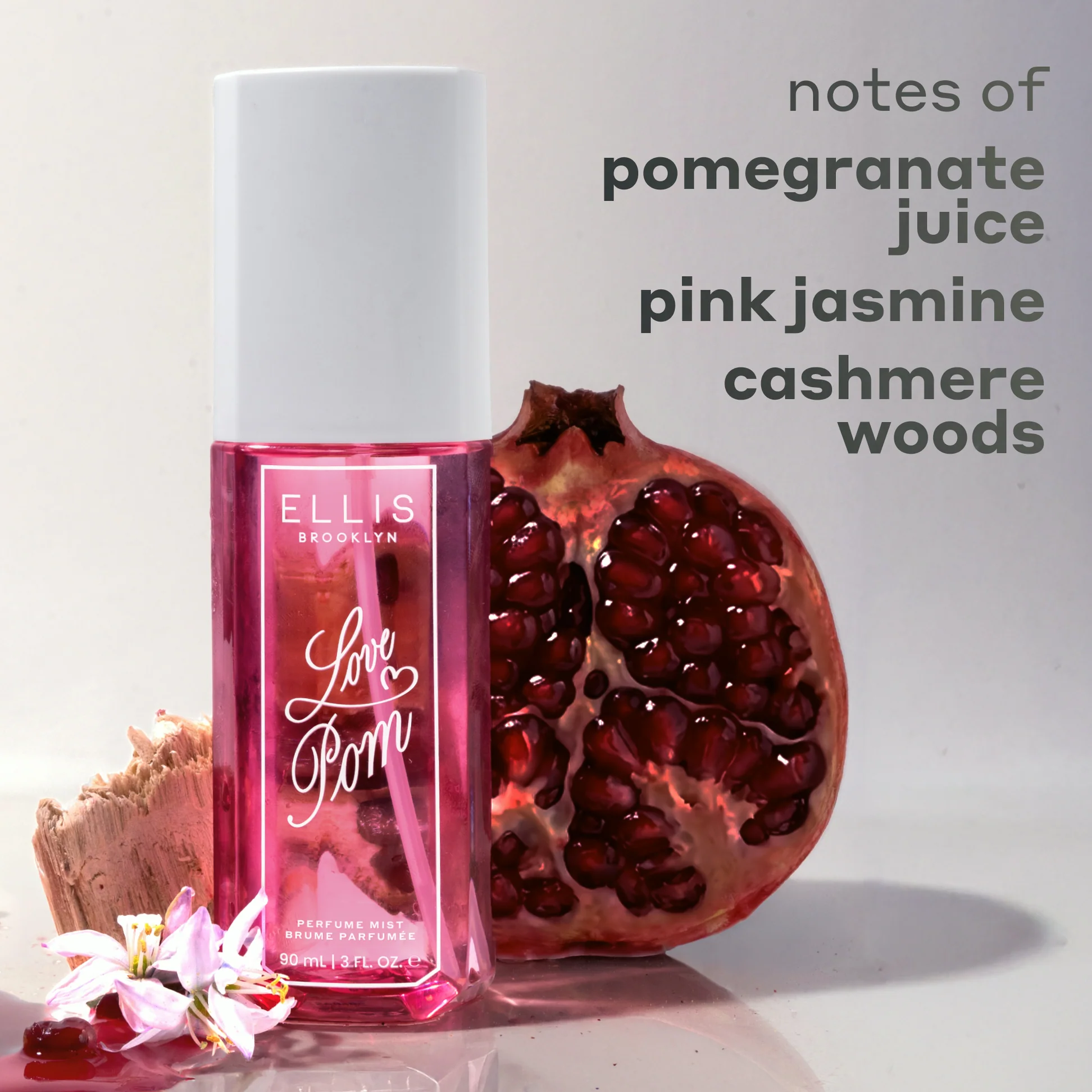Perfume bottle labeled 'Love Pom' with a pomegranate and flowers on a light background