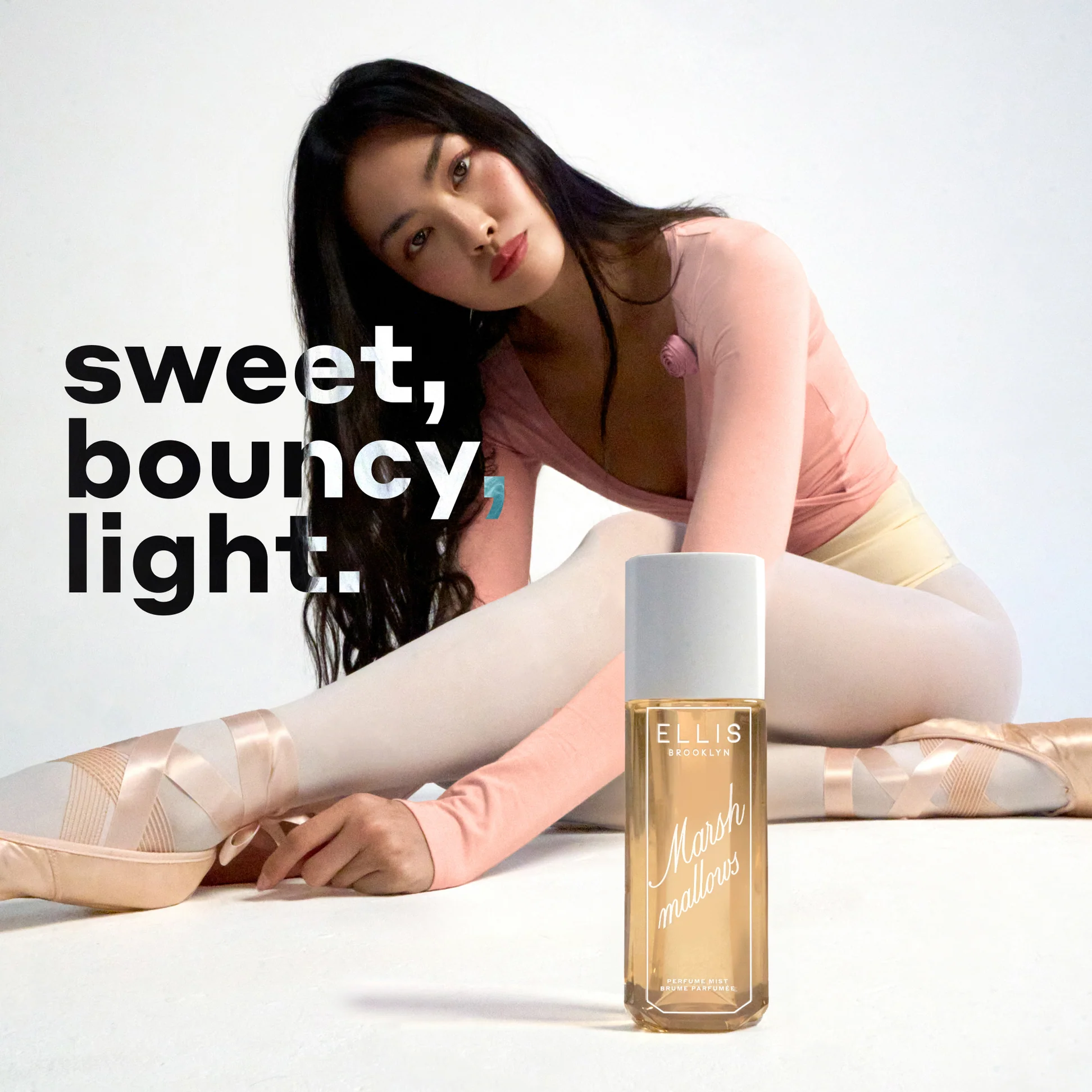 Woman in ballet attire with a bottle of Ellis Brooklyn on a white background