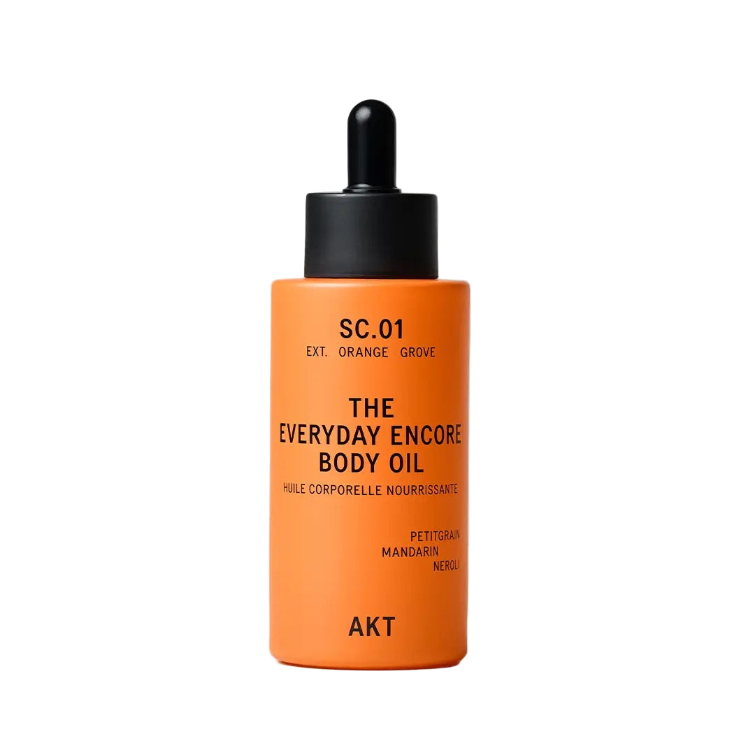 Orange bottle of 'The Everyday Encore Body Oil' with black cap on a light gray background