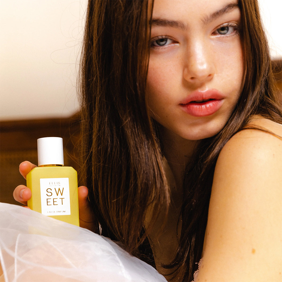 Woman holding a bottle labeled 'Sweet' with a blurred background