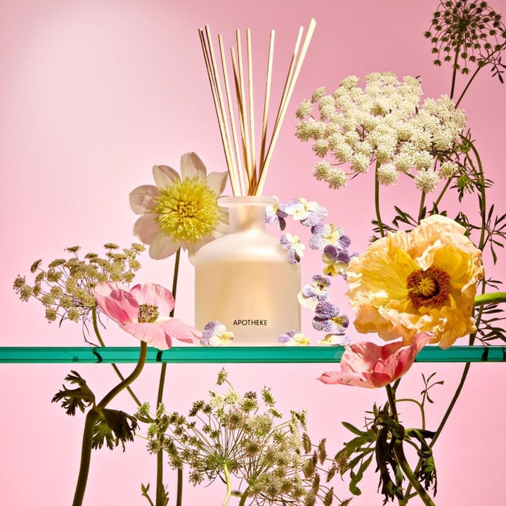 An Apotheke Elderflower  Diffuser with floral elements on a pink background