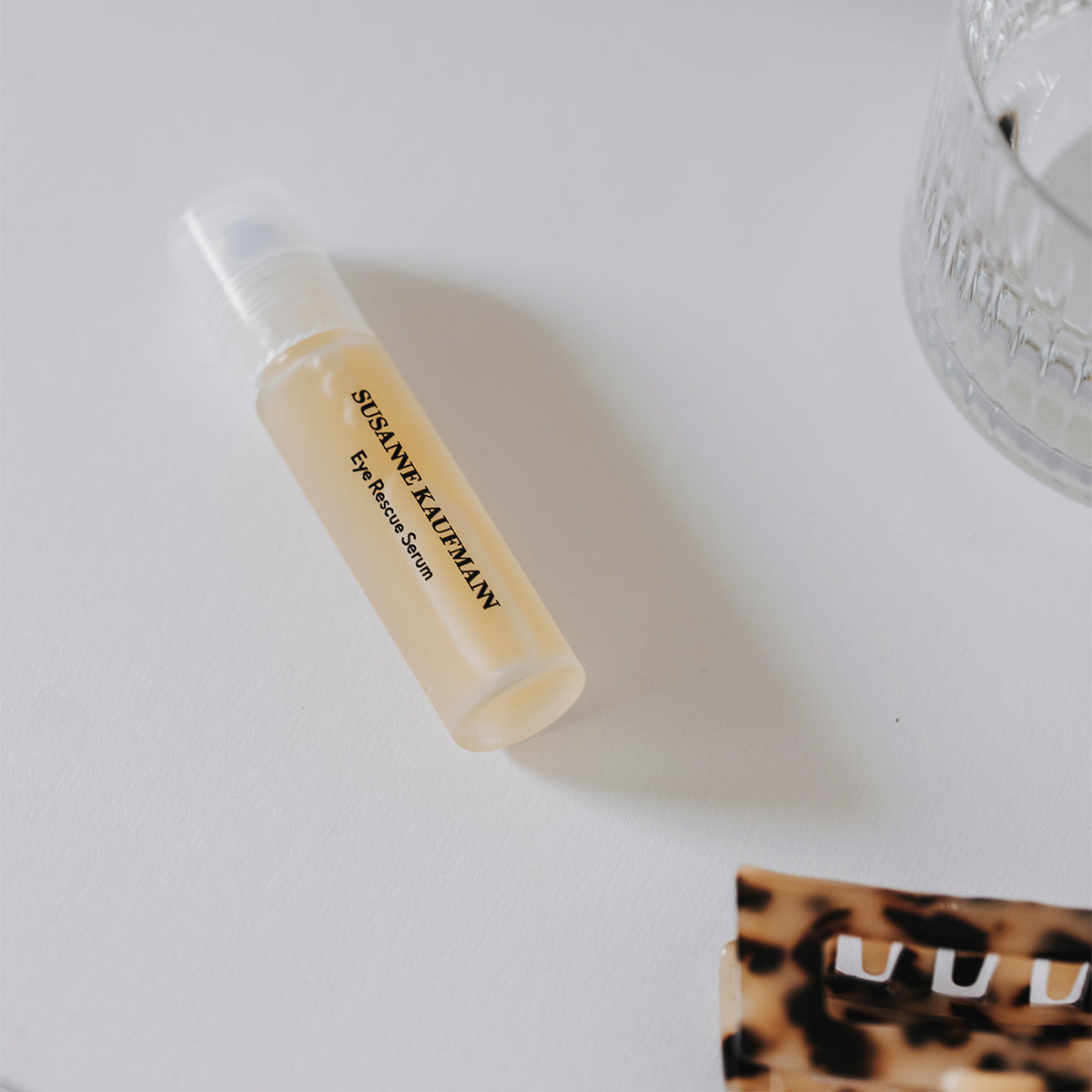 Small beige bottle with a leopard print box on a white surface
