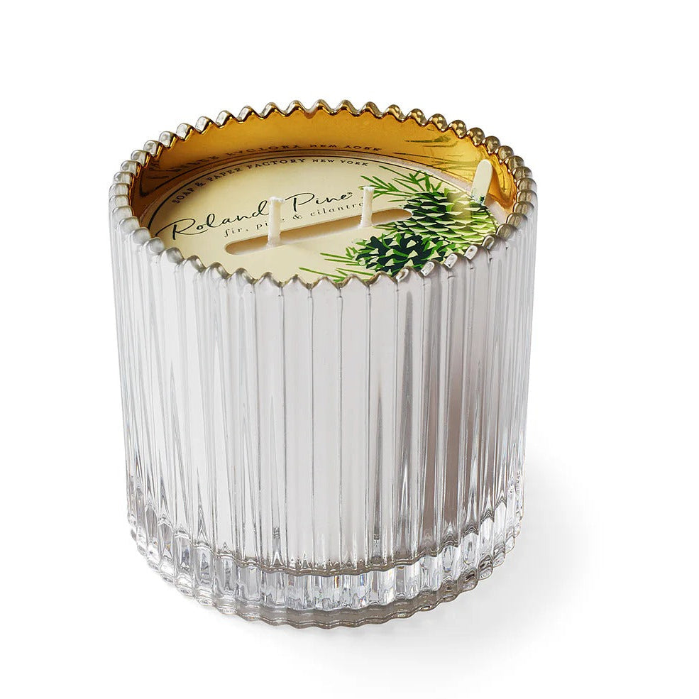 Clear glass candle with decorative lid featuring a pine cone design on a white background