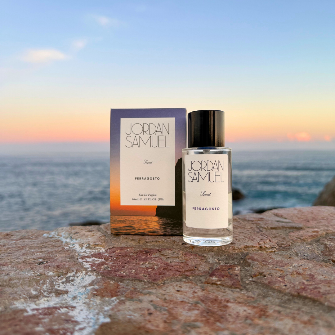 Jordan Samuel perfume bottle and packaging on a rocky surface with a scenic background