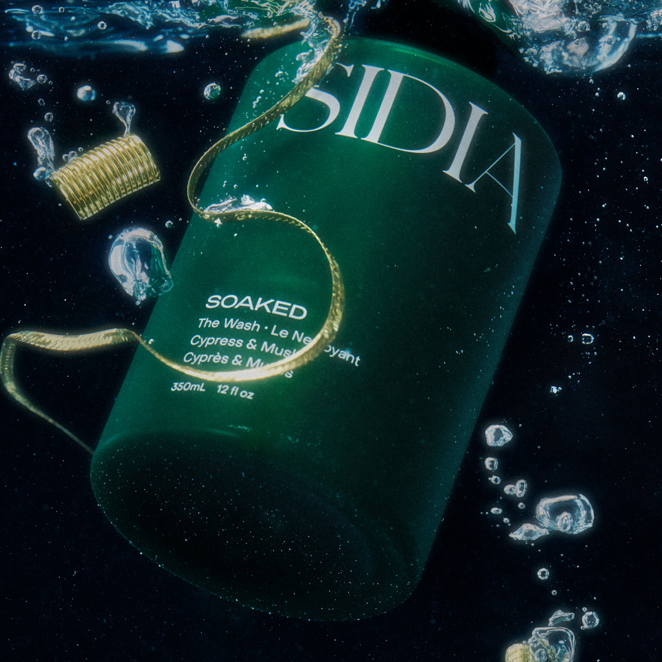 SIDIA "The Wash" under water surrounded by bubbles and gold jewelry