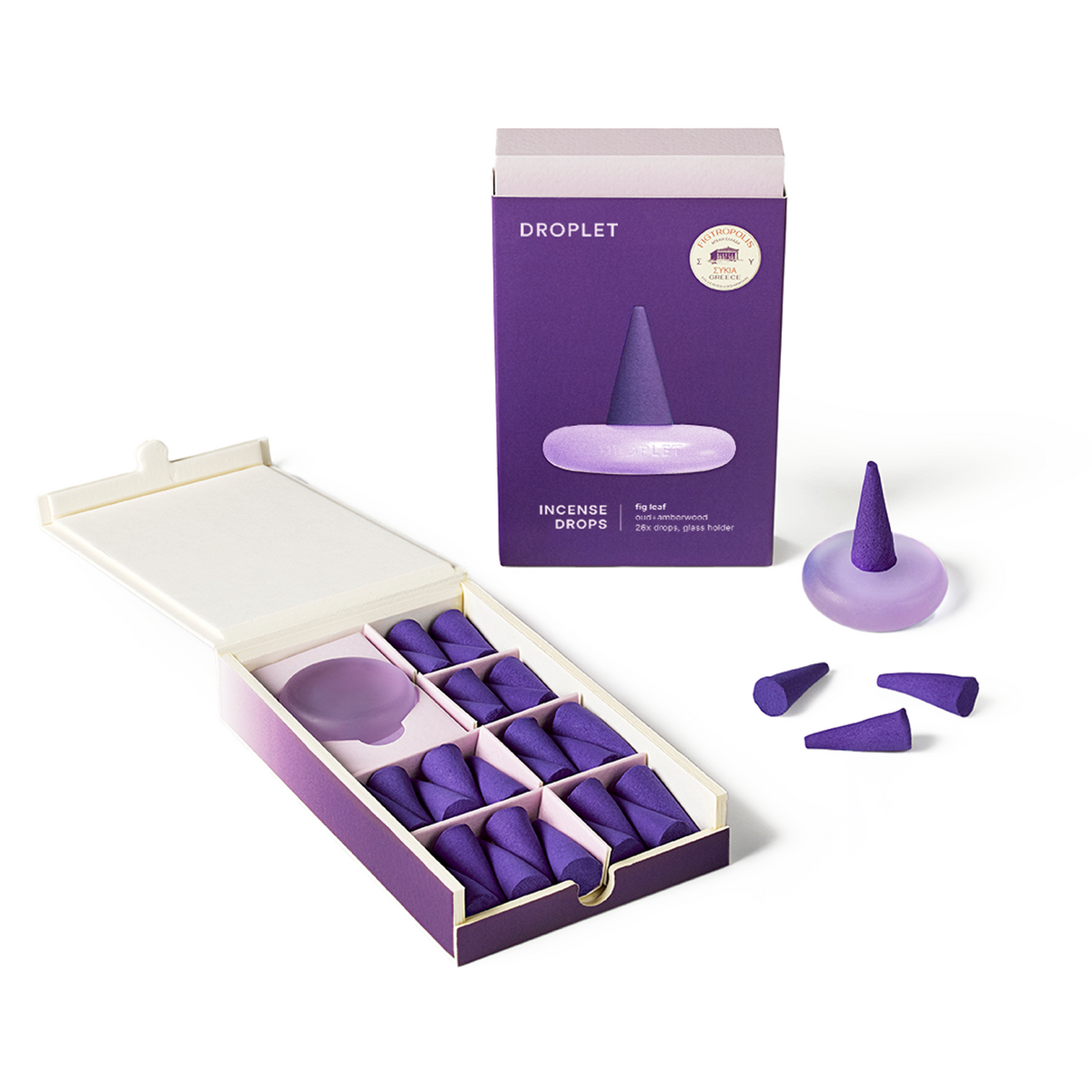 Purple droplet-shaped balance drops displayed in an open box with their retail packaging and a few loose pieces on a clean white background.